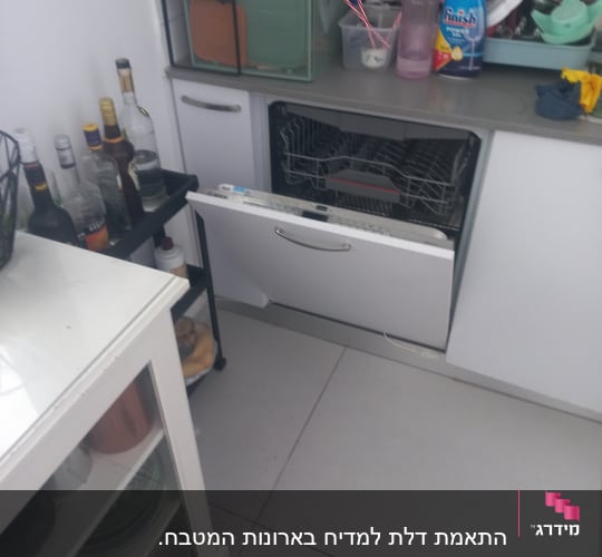 מטבח עם מדיח כלים פתוח וכלים על השיש